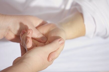 Picture La main d'une personne allongée est tendue et tenue entre les mains d'une autre personne